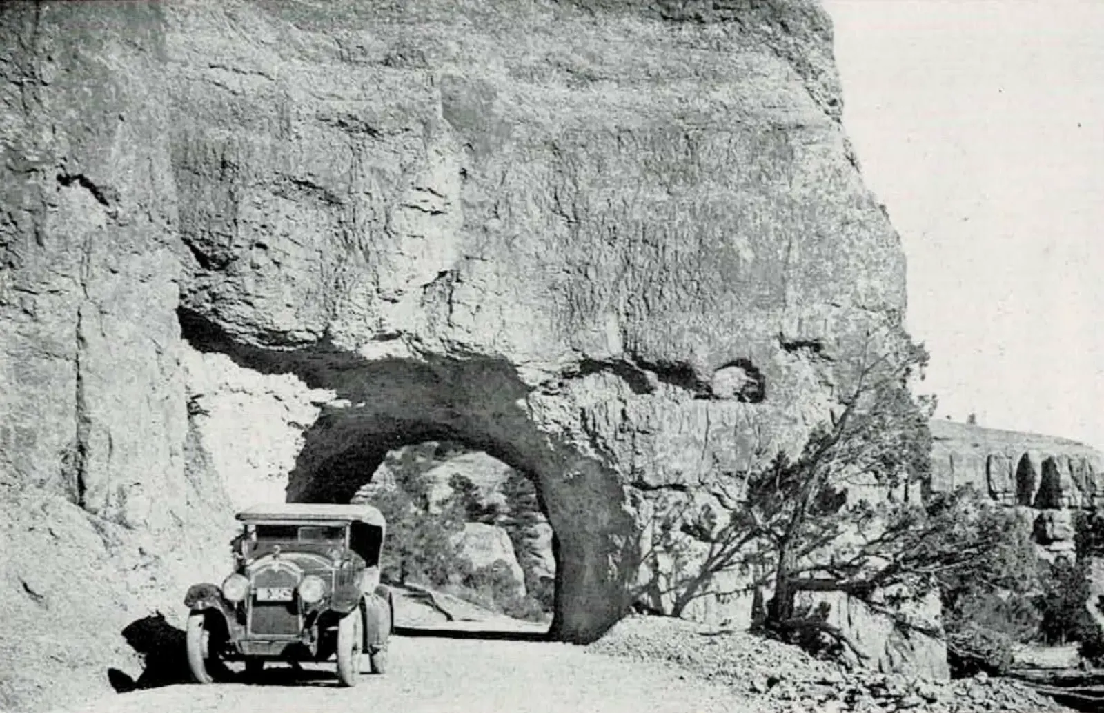 Automobile passing through Red Canyon arch on the Bryce Canyon road