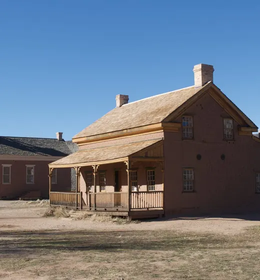 Wide view of Grafton ghost town with schoolhouse, farmhouse, and ranch gate