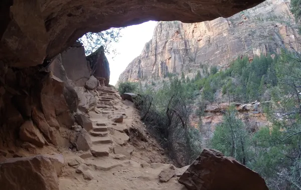 A carved sandstone alcove with stone steps along the Canyon Overlook Trail in Zion