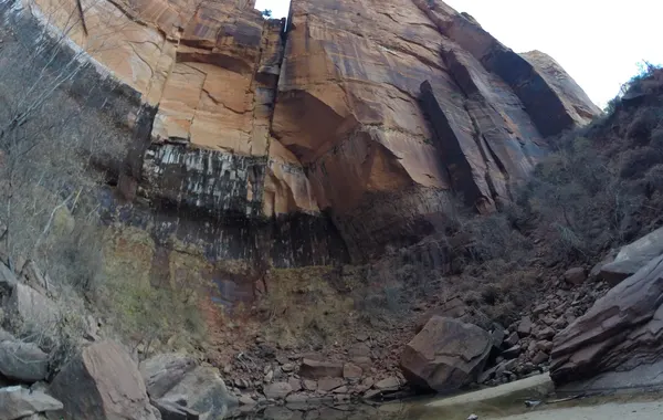 A water-streaked sandstone alcove wall above a pool on the Emerald Pools trail