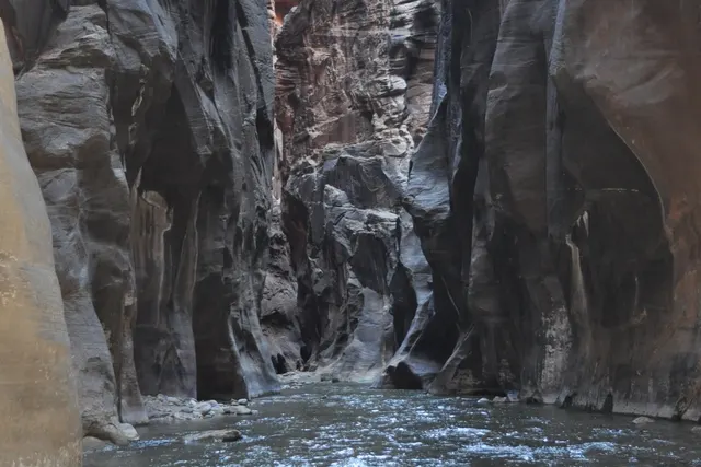 A river running through a narrow canyon between smooth dark walls