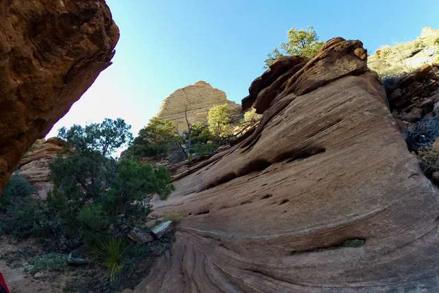 Smooth, curved sandstone ledges with a blue sky behind